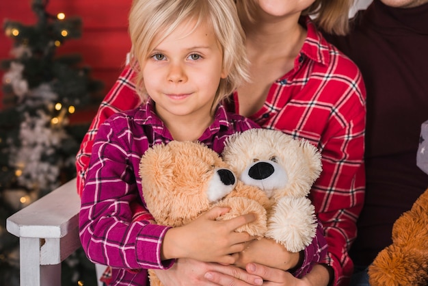 Улыбается девочка держит плюшевых медведей