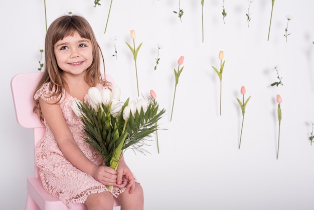 Foto gratuita colpo medio sorridente dei tulipani della tenuta della ragazza