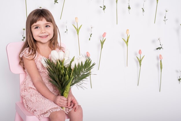 Smiling girl holding tulips medium shot