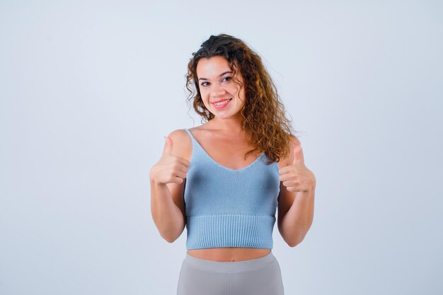 Smiling girl is looking at camera by showing perfect gestures on white background