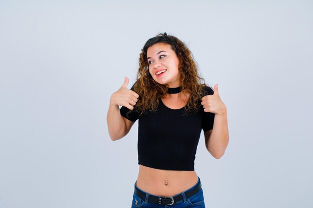 Smiling girl is looking left by showing perfect gestures on white background