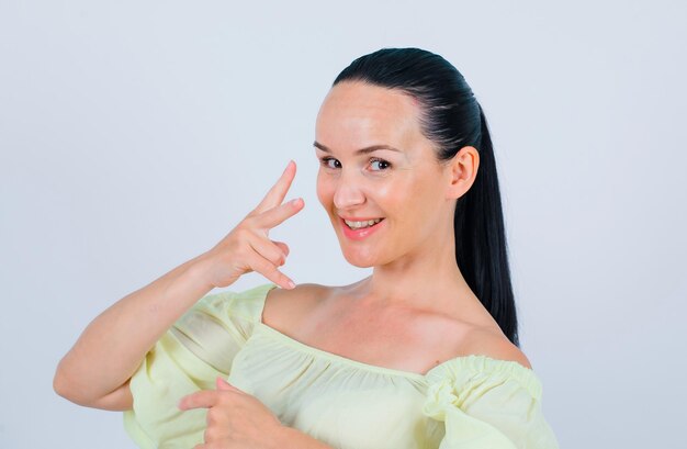 Smiling girl is showing two getsure on white background