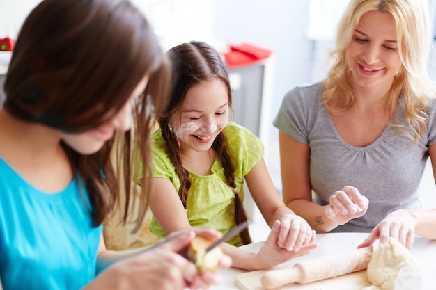 Foto gratuita sorridente bambina impastare la pasta della pizza