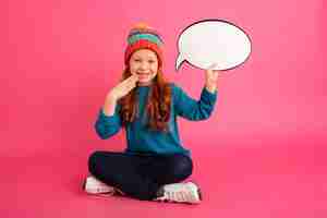 Free photo smiling girl looking to camera and holding bubble speech