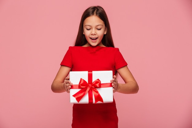 Smiling girl looking at gift in hands and smiling isolated