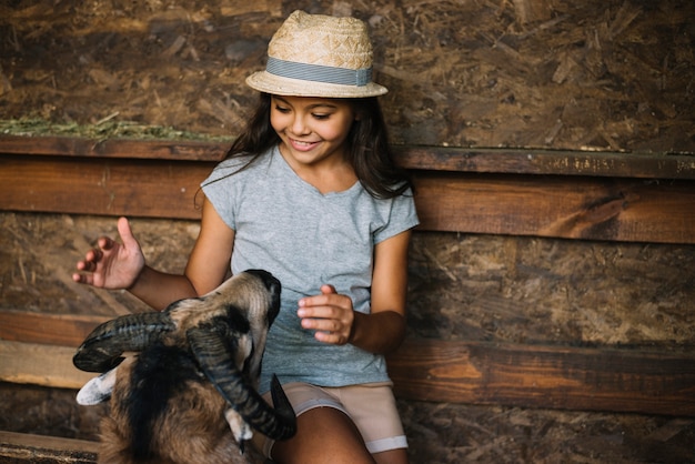 Free photo smiling girl loving sheep in the barn