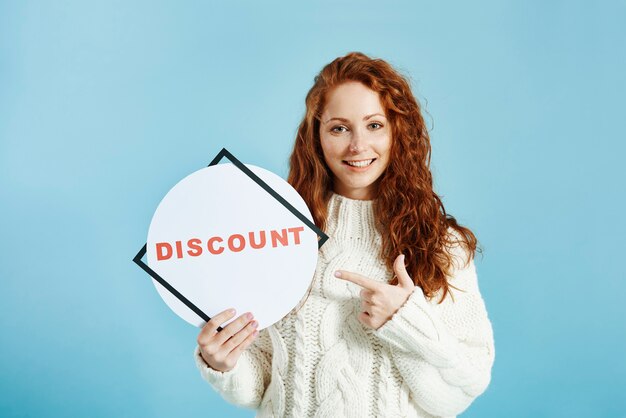 Smiling girl showing banner of sale