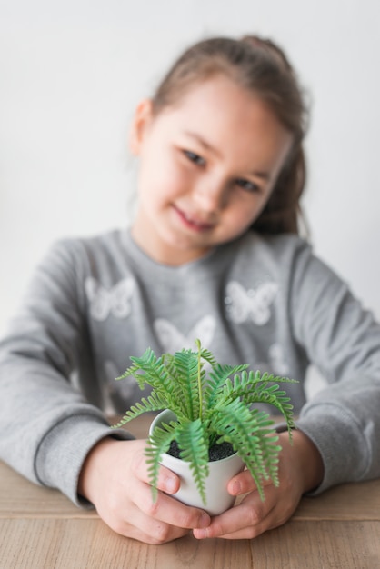 Smiling girl showing plant