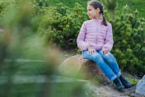 Free photo smiling girl sitting outdoors