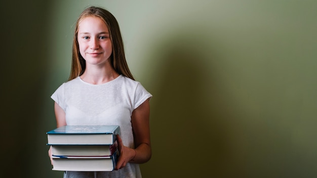 Smiling girl standing with books