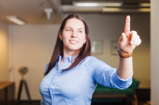 Free photo smiling girl touching air with finger