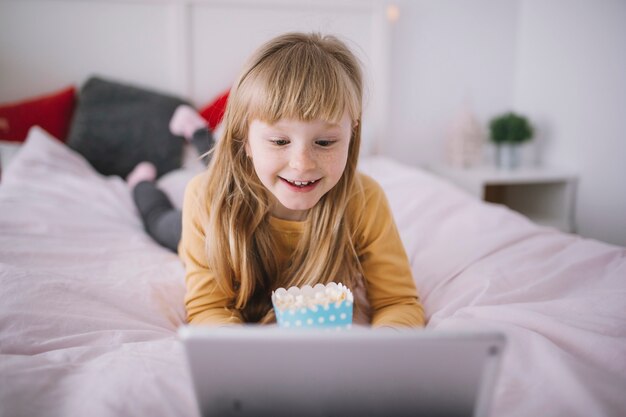 Smiling girl watching movie on tablet