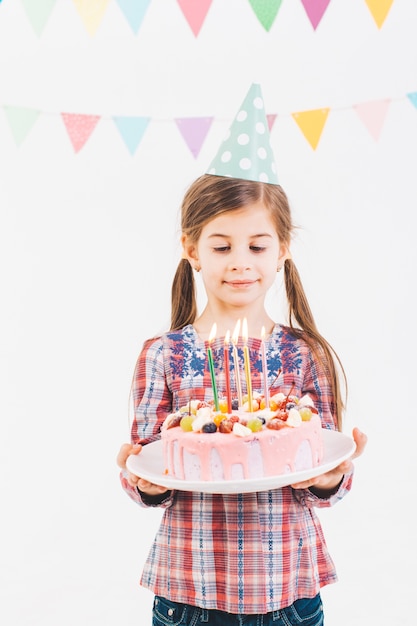 誕生日ケーキを持つ少女の笑顔