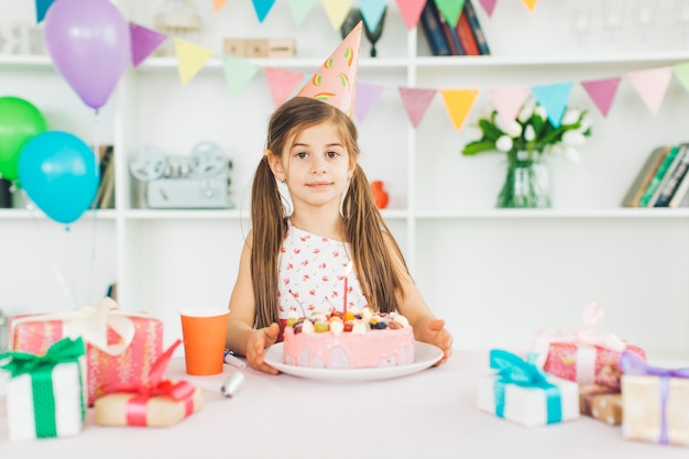 誕生日ケーキを持つ少女の笑顔