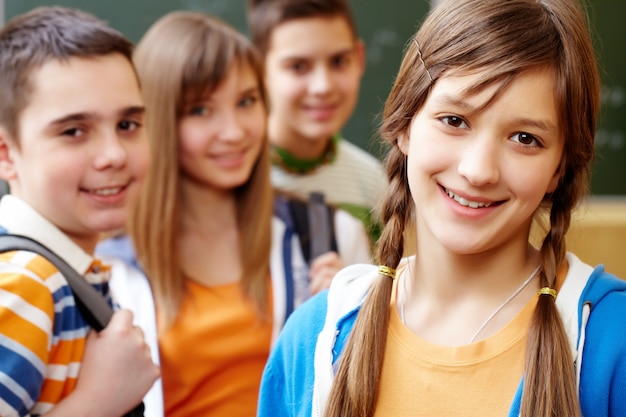 Smiling girl with classmates behind her