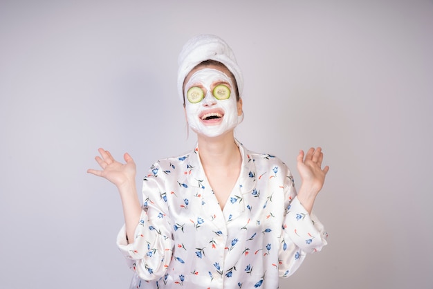 Free photo smiling girl with creamy masc and cucumber slices