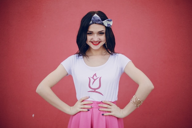 Free photo smiling girl with a hand on the face and red background