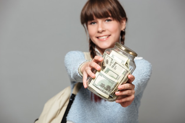 Free photo smiling girl with jar full of money