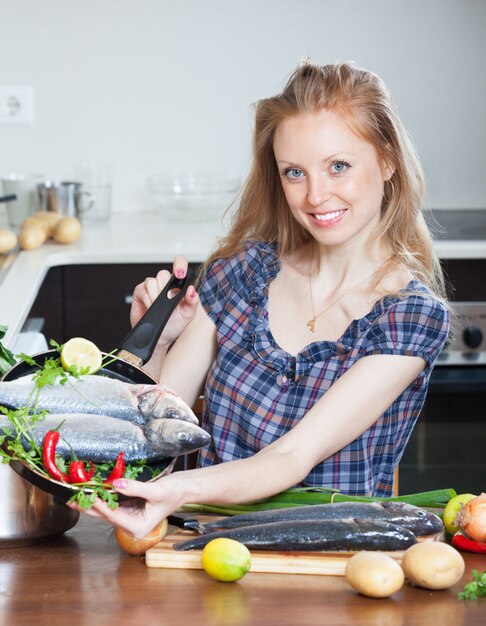 Smiling girl with raw seabass fish