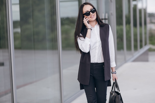 Free photo smiling girl with sunglasses talking on her phone