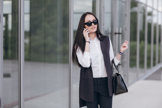 Smiling girl with sunglasses talking on her phone