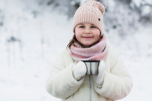 Smiling girl with thermos cap