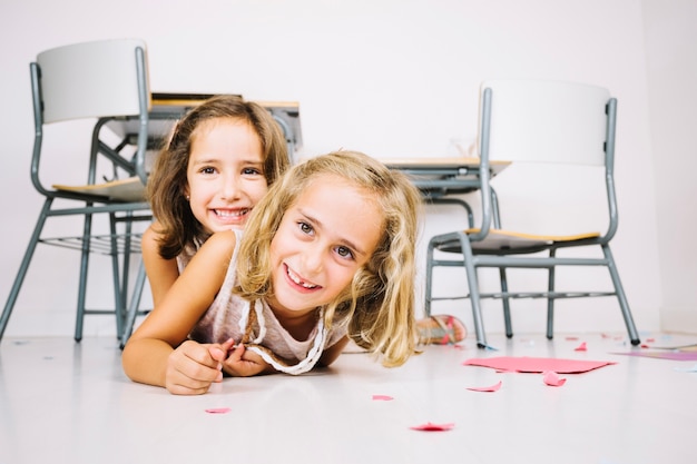 Ragazze sorridenti che si trovano sul pavimento