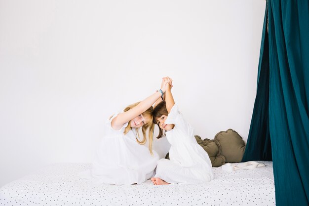 Smiling girls sitting on bed