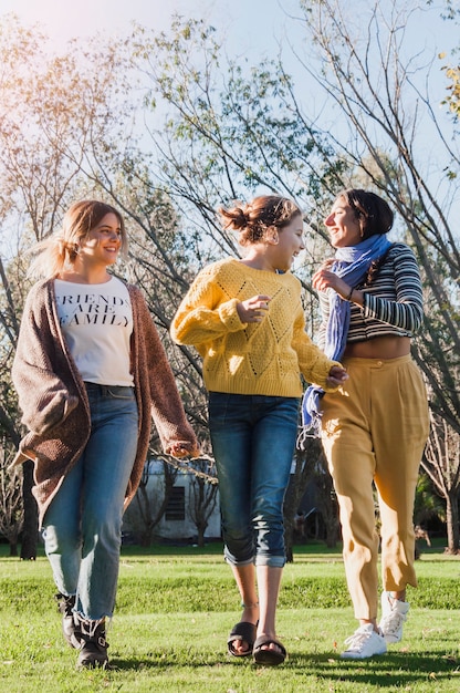 Ragazze sorridenti che camminano sull'erba verde nel parco