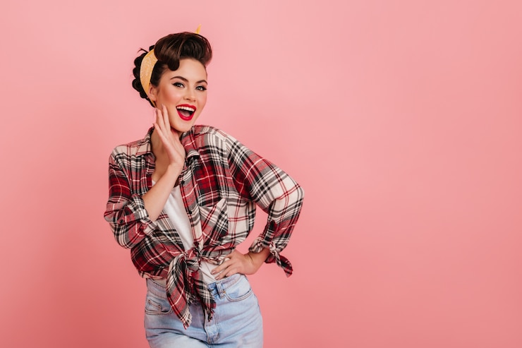 Free Photo smiling gorgeous girl in checkered shirt posing on pink background. studio shot of good-looking pinup woman.