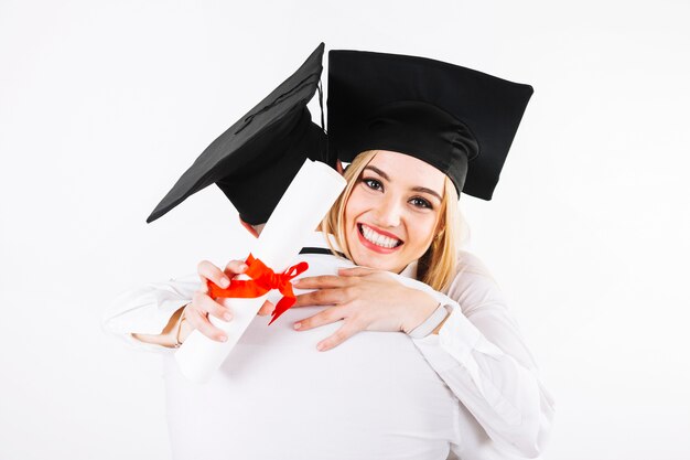 Smiling graduating woman embracing man