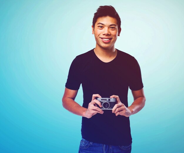 Smiling guy showing the camera over blue background