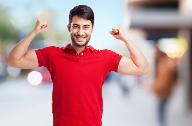Smiling guy showing his muscles