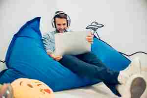 Free photo smiling guy with headphones and laptop