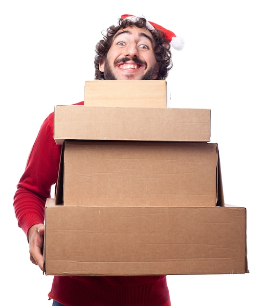 Smiling guy with santa hat showing cardboard boxes