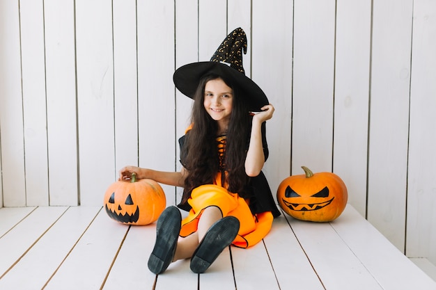 Улыбающаяся ведьма Хэллоуина с тыквами