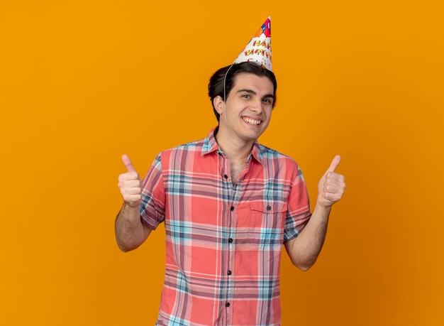 Smiling handsome caucasian man wearing birthday cap thumbs up 