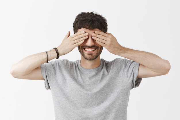 Foto gratuita bel ragazzo sorridente in posa contro il muro bianco