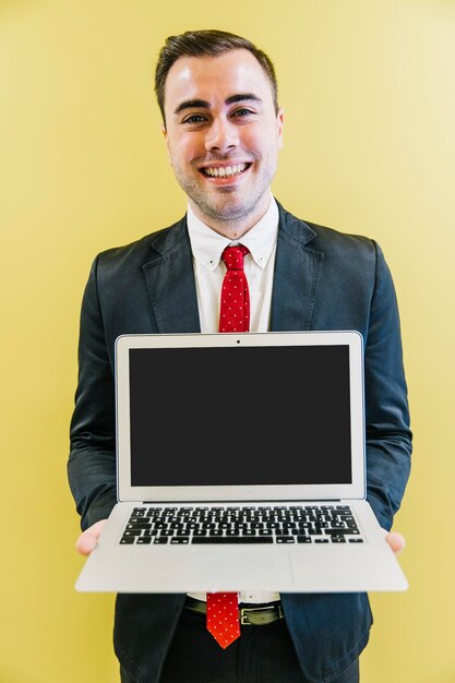 Smiling handsome man showing laptop