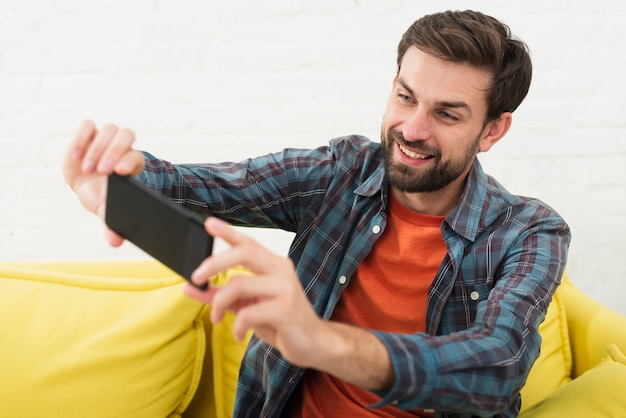 Selfieを取って笑顔のハンサムな男