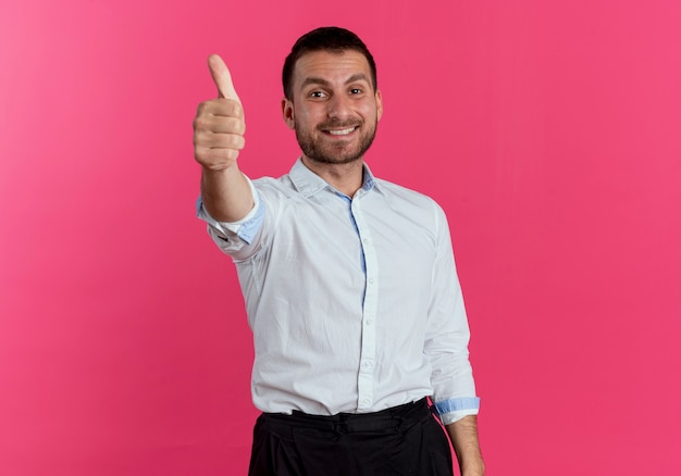 Smiling handsome man thumbs up isolated on pink wall