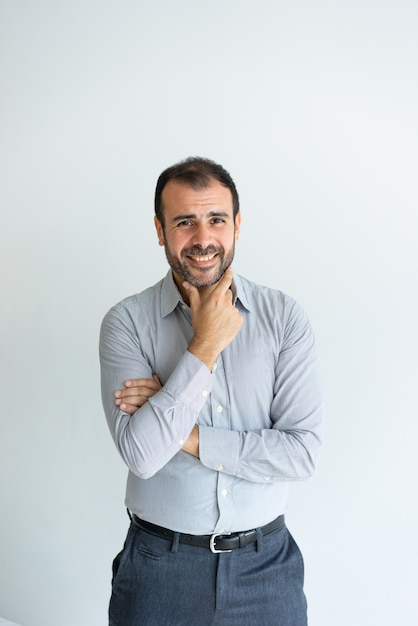 Free photo smiling handsome man touching chin and looking at camera