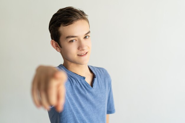 Smiling handsome young man pointing at you