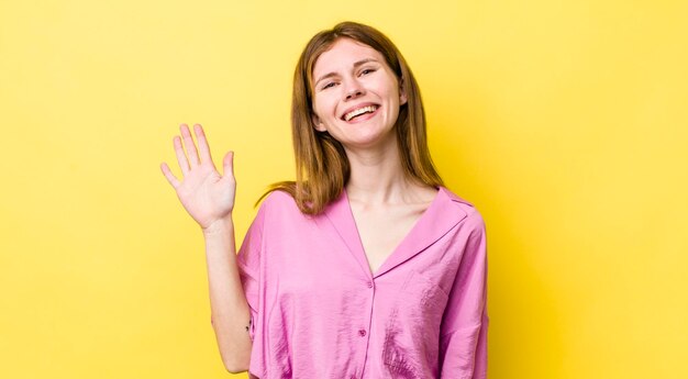 Smiling happily and cheerfully waving hand welcoming and greeting you or saying goodbye