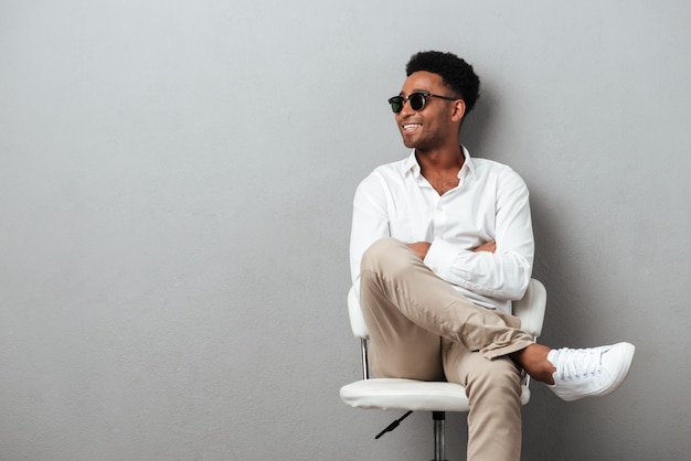 Smiling happy african man posing in a chair