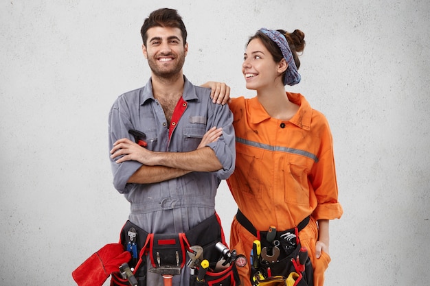 Foto gratuita gli elettricisti felici sorridenti indossano l'uniforme, hanno un'espressione gioiosa.