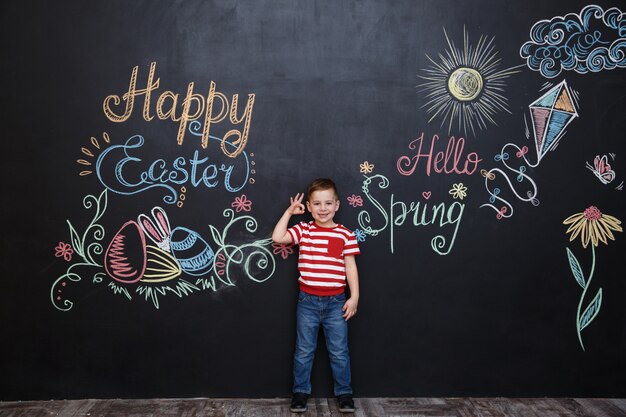 Smiling happy little boy standing and showing