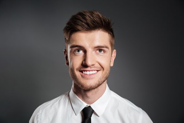 Smiling happy man in shirt looking up at copy space