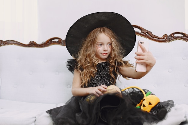 Free photo smiling happy positive little girl witch in carnival halloween costume