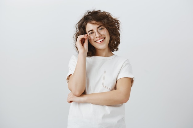 Sorridendo felice braccia incrociate femminili di successo e guardando fiducioso